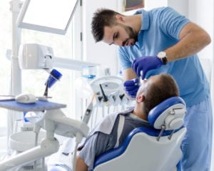 Patient Undergoing Tooth Extraction in Dental Office Patient Undergoing Tooth Extraction in Dental Office